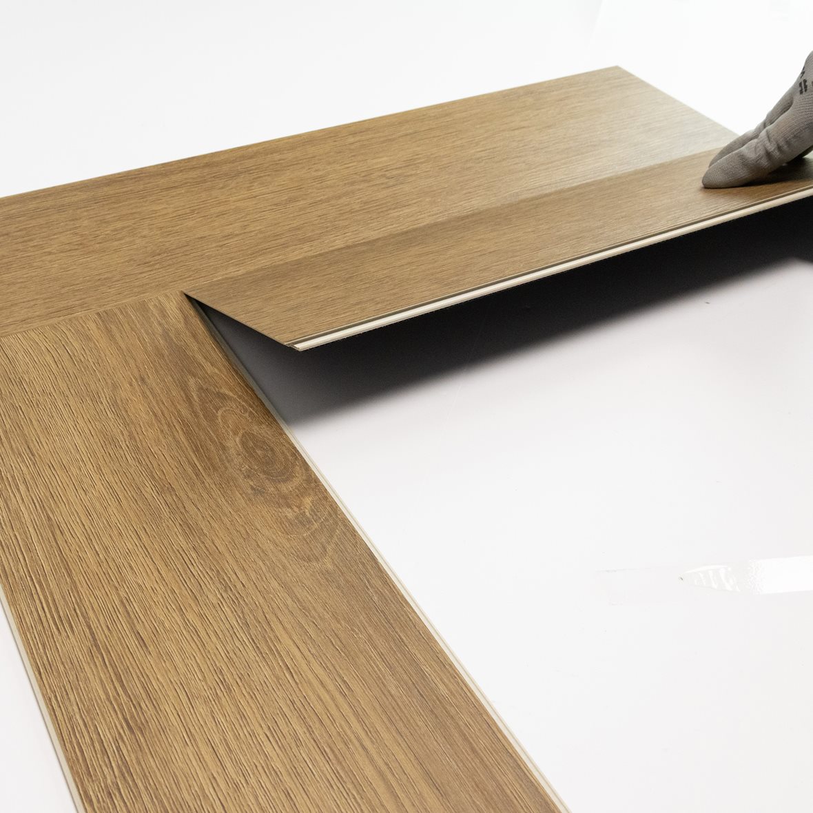 Pontillisen kalanruotovinyylilankun asennus. Lankun pitkän sivun pontti viedään toisen lankun vastakappaleeseen kiinni vinossa kulmassa