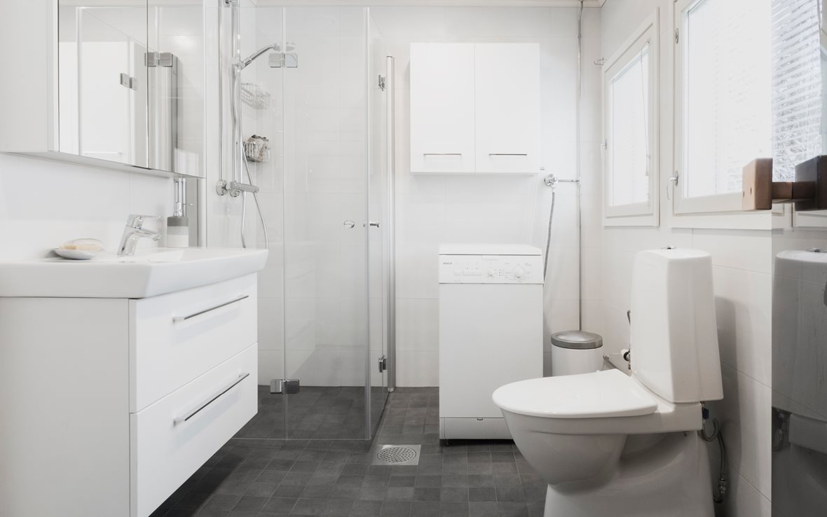 Valkoinen kylpyhuone ja tilava sauna